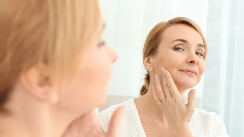 Woman applying cream to face