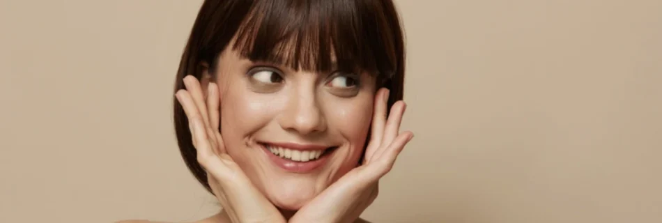 Woman smiling with hands on face