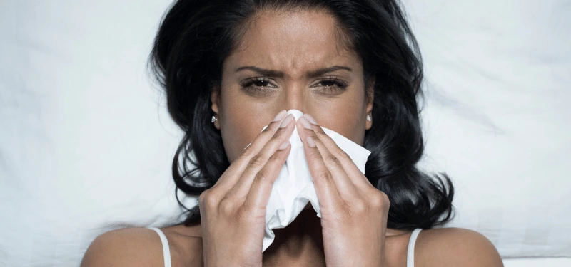 Woman with hayfever blowing nose