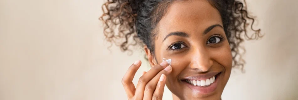 Woman applying sunscreen on her face as part of her skincare routine