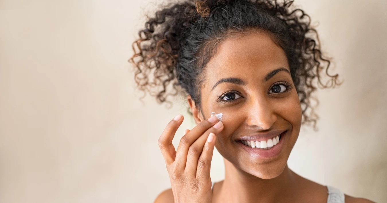 Woman applying sunscreen on her face as part of her skincare routine