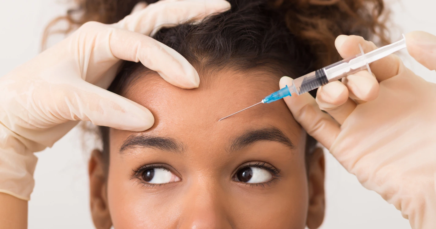 Close-up of a woman receiving a Botox forehead injection, representing common Botox myths and the truth behind the treatment.