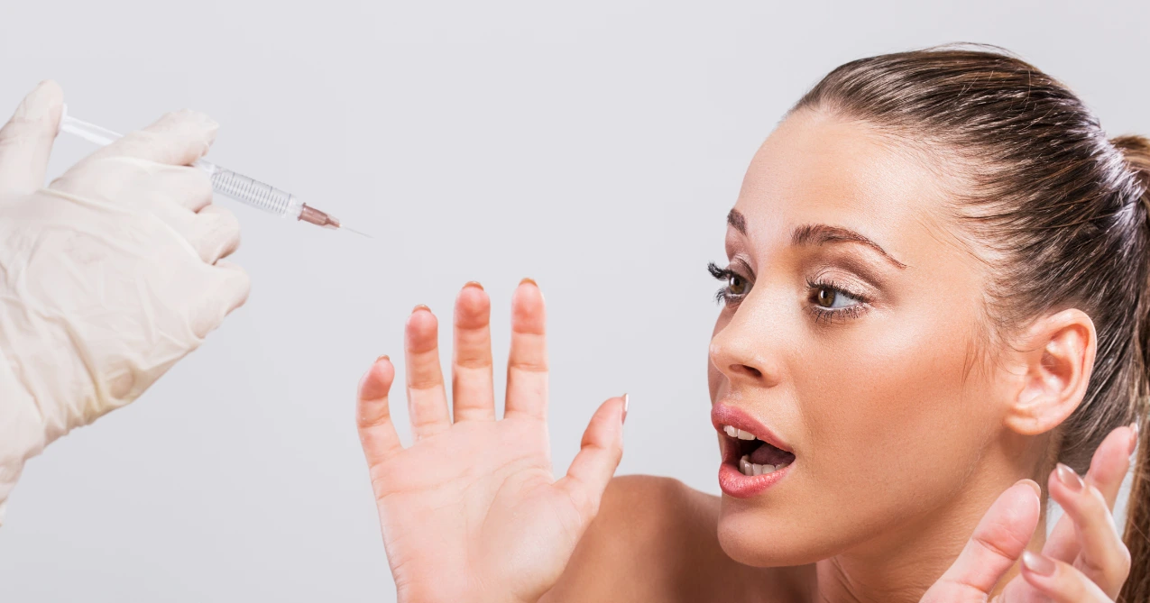 A woman looking worried while thinking about cosmetic injections, representing common Botox myths and concerns, questioning is botox safe.