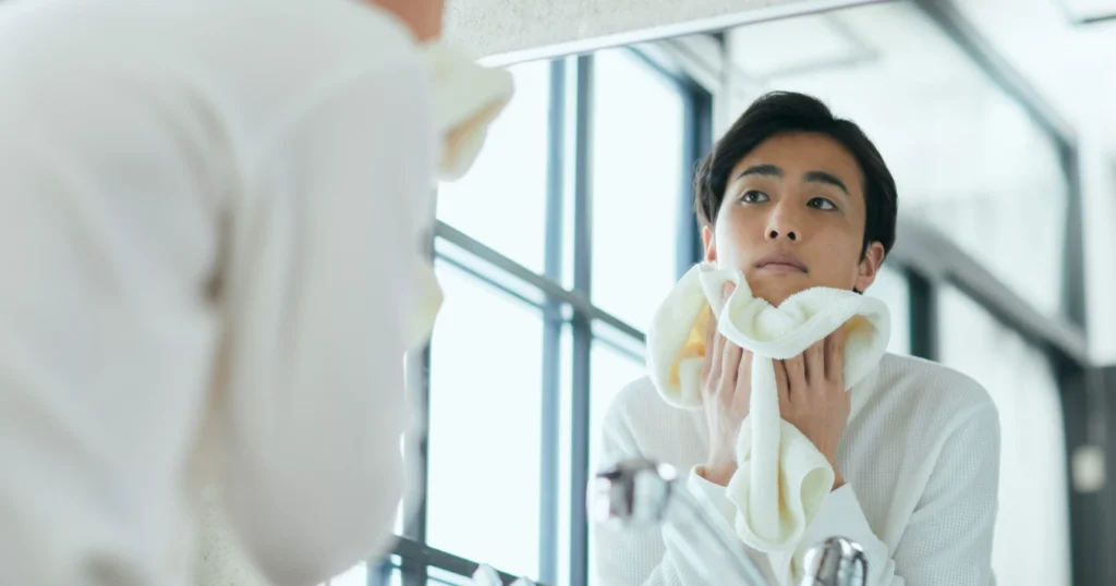 Male looking in the mirror at the dry skin on his face