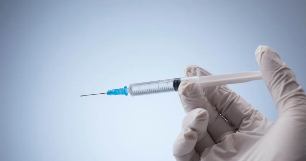 Pre-filled syringe being held by Dr Javed in preparation for Penis Filler injections